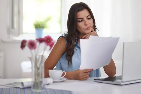 How to Budget for AC Repairs Costs - woman looking at bills with puzzled expression on her face